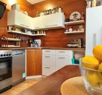 A kitchen in a 2-room apartment with a wood-patterned floor and fruit on the table.