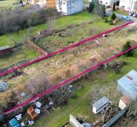 Residential plots in the village of Nováčany surrounded by gardens and nearby houses.