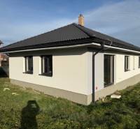 A family house in Bretejovce with a dark roof and a white facade, surrounded by a lawn.