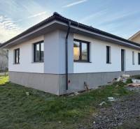 A family house in Bretejovce with white plaster, black windows, and a gable roof.