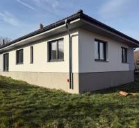 A family house in Bretejovce with a light facade and a dark roof, surrounded by greenery.
