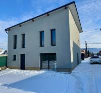 A family house on Gyňovská Street in Čaňa during winter with a white facade and a snowy road.