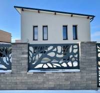A family house on Gyňovská Street in Čaňa with a modern fence and a snow-covered garden.