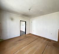 A place in a family house with a wooden decor floor, white walls, and open doors.