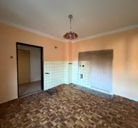 Interior of a family house with a wooden decor floor and a tiled wall ready for installation.