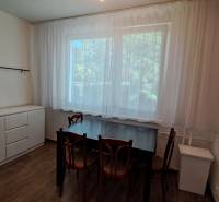 A dining table with wooden chairs and a sideboard in a 2-room apartment.