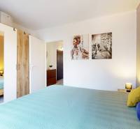 Bedroom in a 3-room apartment with a large bed, mirrored wardrobe, and decorative paintings.