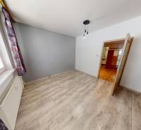 A room in a 3-room apartment with a wooden decor floor and space for furniture.