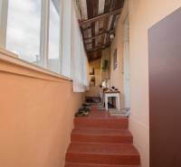 A hallway in a family house with a carpet, stairs, and a table, light walls.