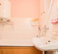 Bathroom with a bathtub, sink, and water heater in a family house.