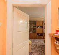A family house with orange walls, wall decoration, and a niche with storage space.