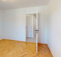 A room in a 4-room apartment with a wood-patterned floor and open doors.