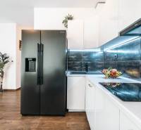 A kitchen in a 2-room apartment with a wooden decor floor and modern appliances.