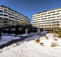 Snow-covered yard and modern buildings of a 2-room apartment on Strojárenská in Košice.