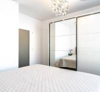 Bedroom with a bed and a built-in wardrobe in a 2-room apartment.