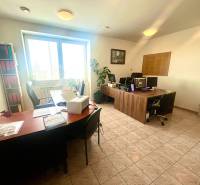 Offices with desks, computers, and plants. Tiled floor.