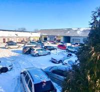 A snowy parking lot full of cars in front of the offices on Osloboditeľov in Košice - the Barca district.