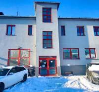 The facade of the office on Osloboditeľov in Košice - Barca district, cars parked on a snowy area.