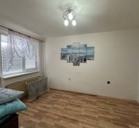 A room in a 3-room apartment with a decorative painting and a floor with a wooden decor.