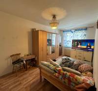 Bedroom with a bed, wardrobe, and television in a 3-room apartment, floor with wooden decor.