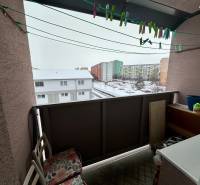 A balcony in a 3-room apartment in Levice, with a view of a snowy street.