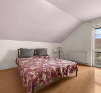 Bedroom in a family house with a wooden decor floor and a double bed.