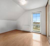 A room with a wooden floor decor, a mirrored wardrobe, and access to a balcony in a family house.