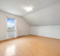 A room in a family house with a wooden decor floor and a skylight.