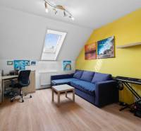 Attic room in a family house with a comfortable sofa, keyboard, and desk.