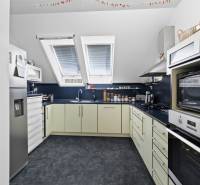 A kitchen in a family house with equipment, slanted roof windows, and appliances.