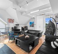 A living room in a family house with leather sofas, a rocking chair, and a dining table.