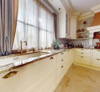 A kitchen in a family house with decorative elements, light cabinets, and a granite countertop.