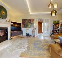 Living room of a family house with a fireplace, comfortable sofa, and decorative artworks.