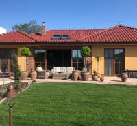 A family house in Bratislava - Jarovce with a terrace, garden, and red roof.