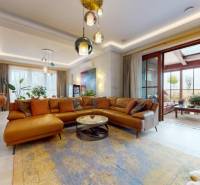 Living room in a family house with a large window, leather sofa, and plants.