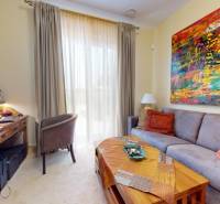Living room of a family house with a sofa, a colorful painting, and a desk.