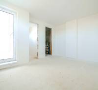 Empty room in a family house with a light floor and a large window.