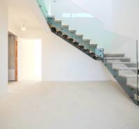 A staircase with glass railing in a family house, floor with wooden decor.