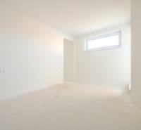 The interior of a family house with white walls and a window, without furniture, bright atmosphere.