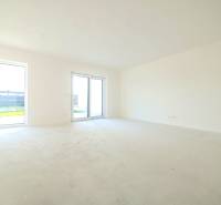 A spacious room with large windows in a family house, floor with wooden decor.