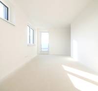 Empty room with large windows and light walls in a family house.