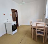 Dining area in a 3-room apartment with a gas stove and simple furniture.