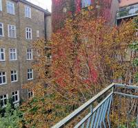 A balcony in a 3-room apartment with a view of buildings and foliage in Bratislava, Staré Mesto.