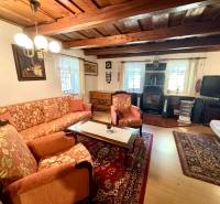 Living room in a family house with a wooden decor floor, cozy furnishings, and a wooden ceiling.