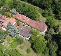 An aerial view of a family house in Vrbovce surrounded by greenery and trees.