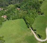 An aerial view of family houses surrounded by forest and meadows in Vrbovce.