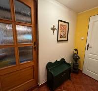Entrance hall with wooden doors, yellow wall, and decorations in a family house.