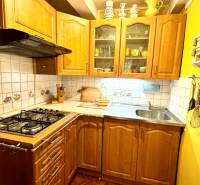 A kitchen in a family house with light wood decor and ceramic tiles.