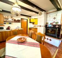 A kitchen in a family house with a stove, fireplace, wooden furniture, and decorative placemats.