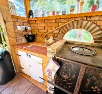 Rustic kitchen in a family house with brick decor and window sills full of mugs.